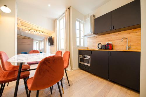 a kitchen with a table and chairs in a room at Dreamyflat - Archives in Paris