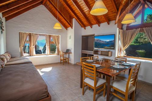 1 dormitorio con 1 cama y comedor con mesa en Costa Brava Apart Hotel & Suites en San Carlos de Bariloche