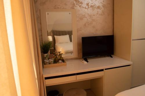 a desk with a television and a mirror at Vila Gama in Lozenets