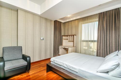 a bedroom with a bed and a chair at Megafun Residance B1 in Baku