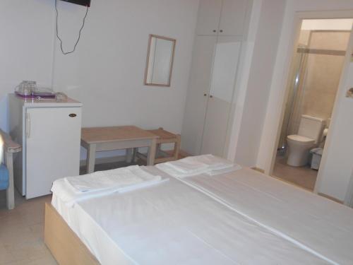a room with a bed and a table and a refrigerator at Villa Fotis in Ligia