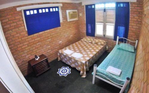 een slaapkamer met 2 bedden in een bakstenen muur bij Casa Laser praia Cumbuco in Cumbuco