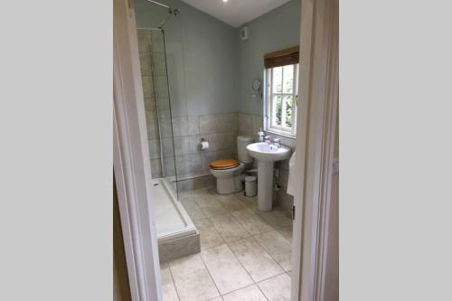 a bathroom with a toilet and a sink and a tub at Private Annex near Melton Mowbray in Melton Mowbray