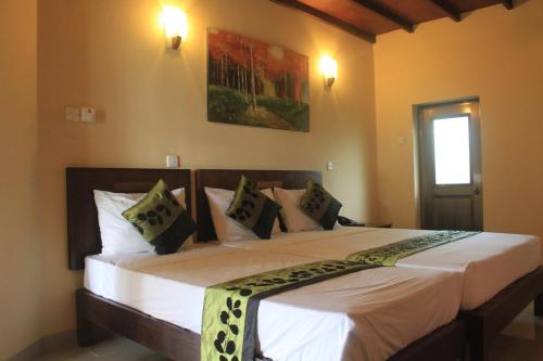 a bedroom with a large bed with white sheets and pillows at Grand 7 Hotel Thalawathugoda in Talawatugoda
