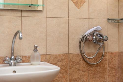 a bathroom with a shower head on a sink at Rooms Maria in Naxos Chora