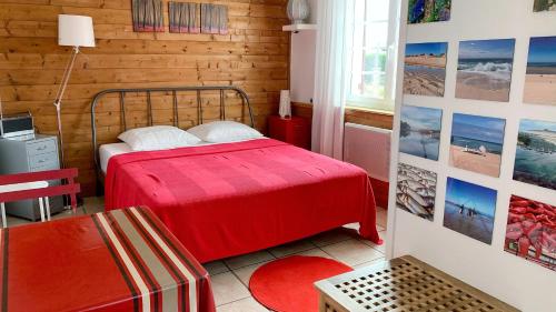une chambre avec un lit rouge dans une pièce dans l'établissement Le Studio Rouge de la Gare, à Vieux-Boucau-les-Bains