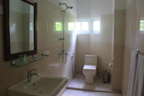 a bathroom with a sink and a toilet and a mirror at Grand 7 Hotel Thalawathugoda in Talawatugoda