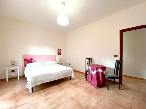a bedroom with a bed and a table and chairs at Giannì Holiday Home - Vesuvio/Pompei in Terzigno