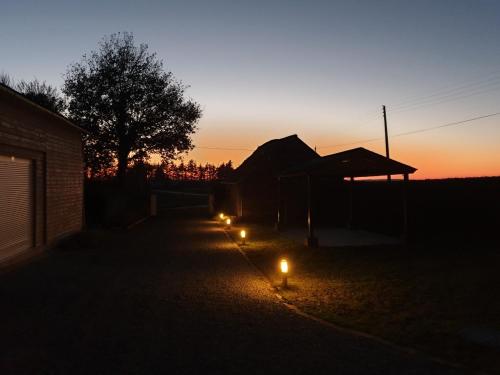 a group of lights in a yard at sunset at Charming traditional 2-Bed Cottage near Plemet in Plémet