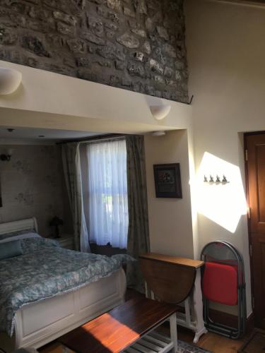 - une chambre avec un lit, une table et une fenêtre dans l'établissement Taliesin at The Poplars, Nr Saundersfoot, à Pembrokeshire