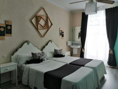 a hotel room with two beds and a window at Hospedaje Botin in Santander