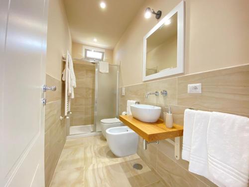W łazience znajduje się umywalka, toaleta i lustro. w obiekcie Maison Sciscì Rooms w mieście San Felice Circeo