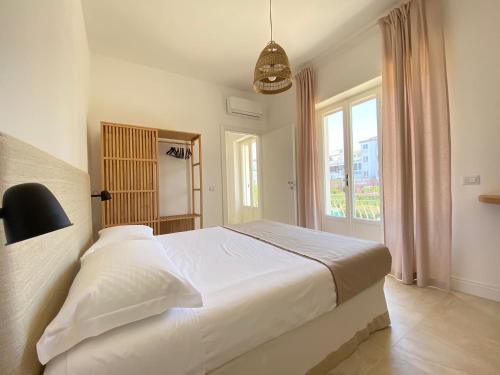 a bedroom with a white bed and a window at Maison Sciscì in San Felice Circeo