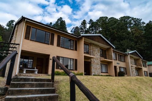 a large house with stairs in front of it at Gooderson Drakensberg Gardens Golf & Spa Resort in Drakensberg Garden