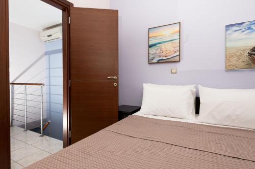a bedroom with a bed and a wooden door at Luxury Dream House in Limenaria