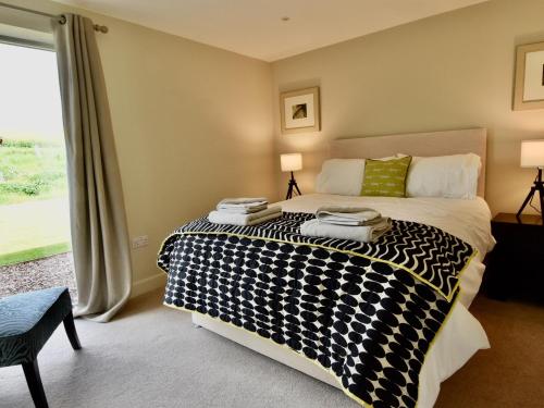 a bedroom with a black and white bed with a window at Birchbank at Chesters Farm in Haddington