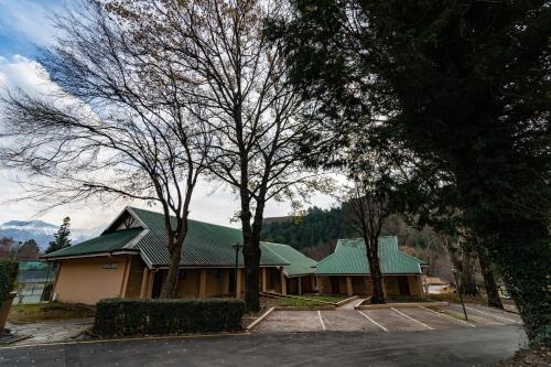 a building with a green roof and two trees at Gooderson Drakensberg Gardens Golf & Spa Resort in Drakensberg Garden