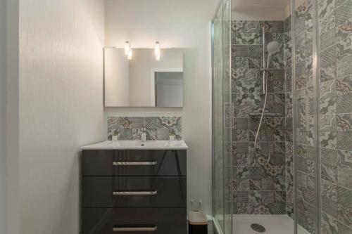a bathroom with a sink and a shower at Logement confort moderne au pied du Front de Mer in Saint-Nazaire