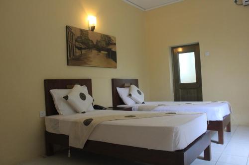 a bedroom with two beds and a window at Grand 7 Hotel Thalawathugoda in Talawatugoda