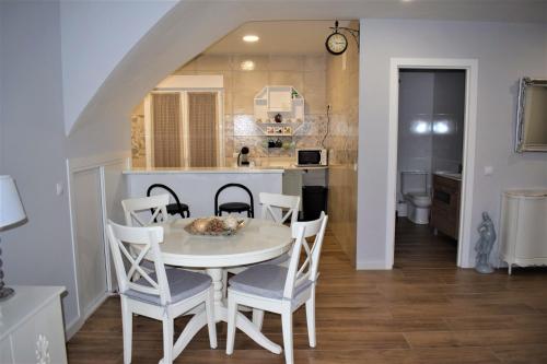 een keuken en eetkamer met een witte tafel en stoelen bij SEVILLA I Y SEVILLA II in La Guardia
