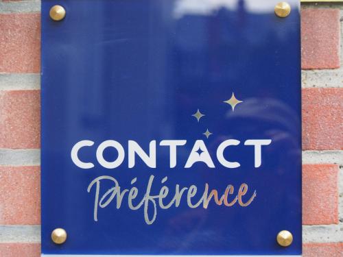 a sign that reads contact performance on a brick wall at Hotel Du Croisé in Marcq-en-Baroeul