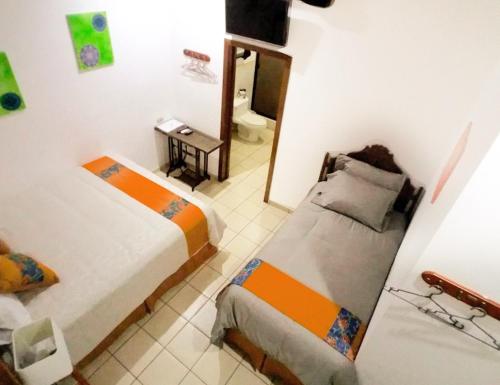 a small room with two beds and a mirror at Hostal Las Puertas in Santa Ana