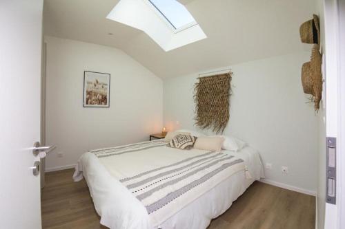 um quarto branco com uma cama grande e uma clarabóia em LOUE ET PASSION - DOMAINE LOUE PAISIBLE - Calme - Terrasse - Parking em Chouzelot