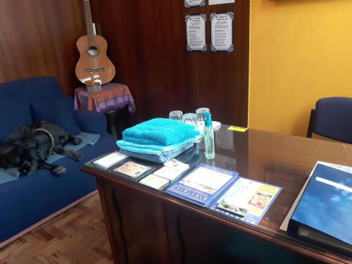a table with a dog laying on a couch and a guitar at Bom Caminha - Private Albergue for Pilgrims in Caminha
