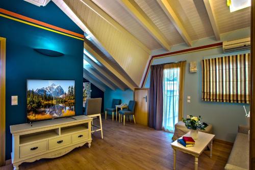 a living room with a flat screen tv on a blue wall at Hotel Maistrali in Parga