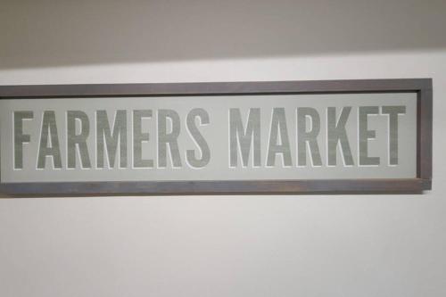 a sign that reads farmers market hanging on a wall at Farm House stay with soaking tub and hot tub barn in Hammond