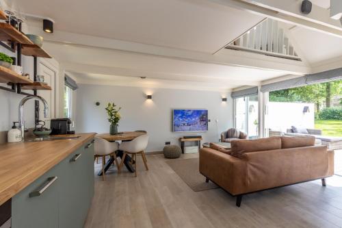 a kitchen and living room with a couch and a table at Limburg Lux 90 in Simpelveld