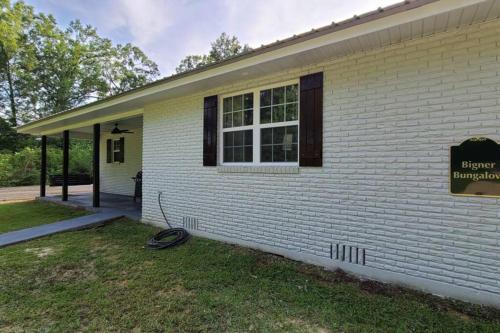 a house with a sign on the side of it at Farm House stay with soaking tub and hot tub barn in Hammond