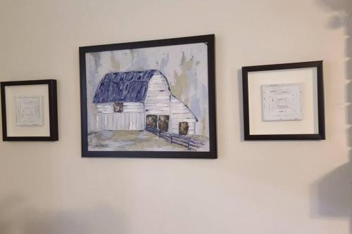 three pictures of a painting of a barn on a wall at Farm House stay with soaking tub and hot tub barn in Hammond
