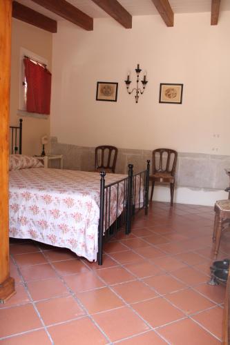a bedroom with a bed and two chairs at B&B Vecchia Suppenna in Andria