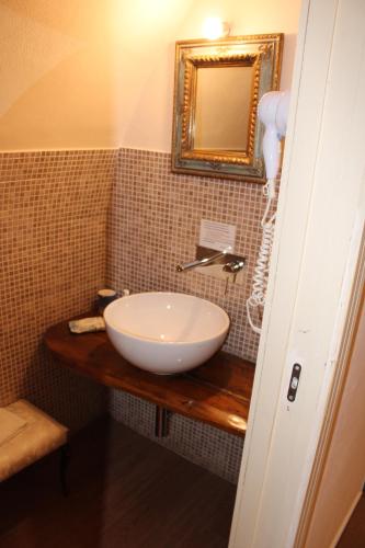 a bathroom with a white bowl sink on a wooden counter at B&B Vecchia Suppenna in Andria