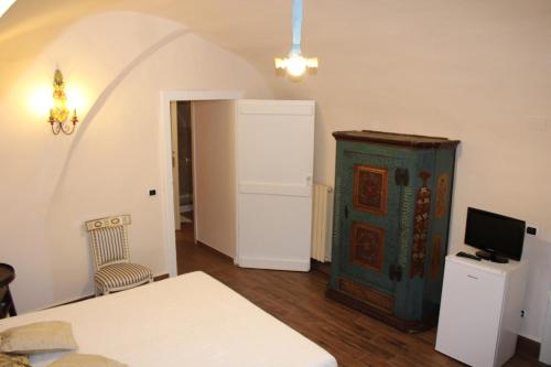 a bedroom with a bed and a cabinet and a television at B&B Vecchia Suppenna in Andria