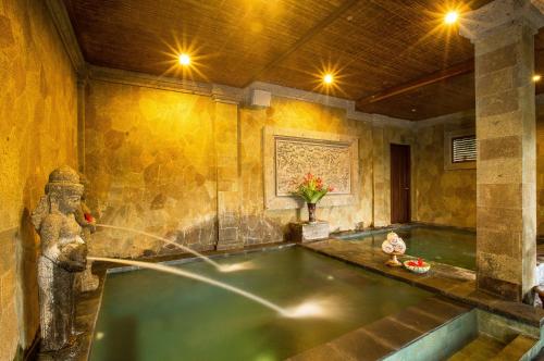 a hot tub in a room with a fountain at Bliss Ubud Spa Resort in Ubud