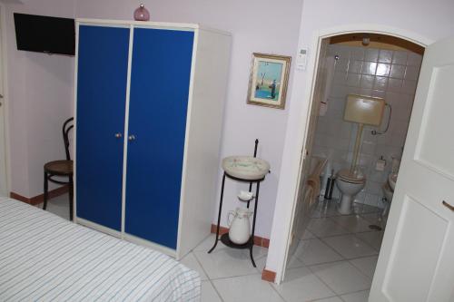 a bedroom with a blue closet and a bathroom at B&B Vecchia Suppenna in Andria