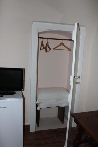 a room with a closet with a tv and a door at B&B Vecchia Suppenna in Andria