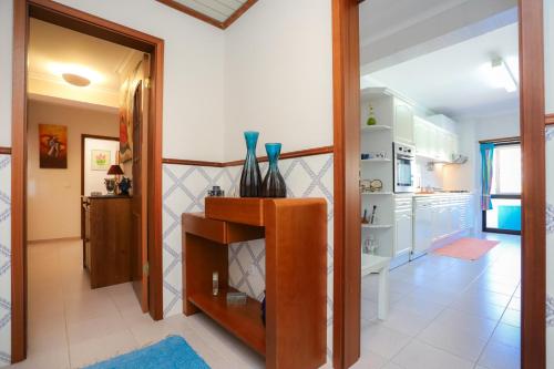 a room with a kitchen with a counter with vases on it at Brasil Avenue by Rent4All in Figueira da Foz