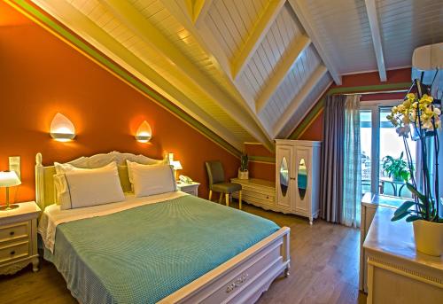 a bedroom with a large bed with an orange wall at Hotel Maistrali in Parga