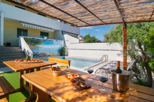 a patio with a table and a swimming pool at Villa Koludrovac in Kaštela
