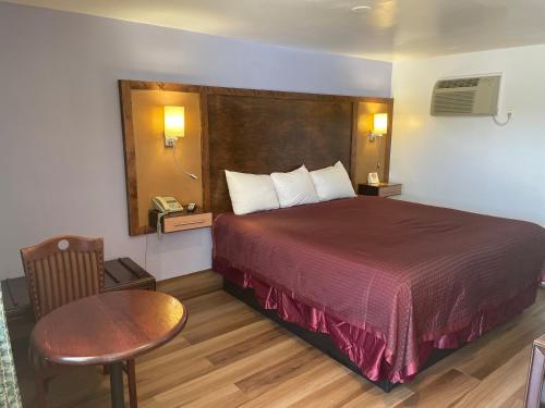 Habitación de hotel con cama, mesa y teléfono en Scottish Inn - North Tonawanda, en Tonawanda