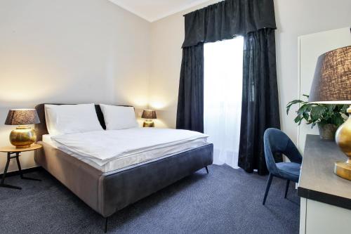 a hotel room with a bed and a window at Zámecký hotel & Wellness in Poděbrady