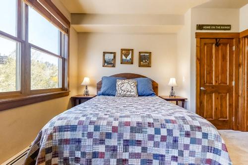 um quarto com uma cama e duas janelas em Cornerstone at the Moraine Townhome 40 em Steamboat Springs