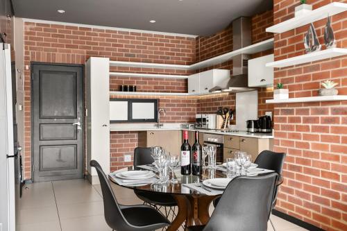 a dining room with a brick wall and a table and chairs at Easy Stay - The Vantage Rosebank in Johannesburg