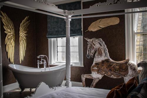 a bedroom with a tub and a horse on the wall at The Auction House in Morpeth