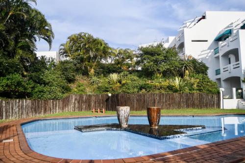 a swimming pool with two vases on top of it at Palm Cove - 10 Thira, Santorini, best view over Thompsons Beach in Ballito