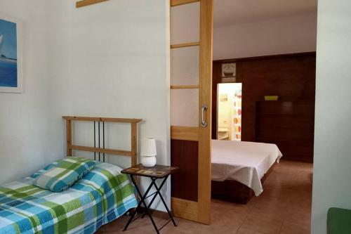 1 dormitorio con cama y espejo en Apartamento-Bungalow con jardín y garaje, en Santa Cruz de Tenerife