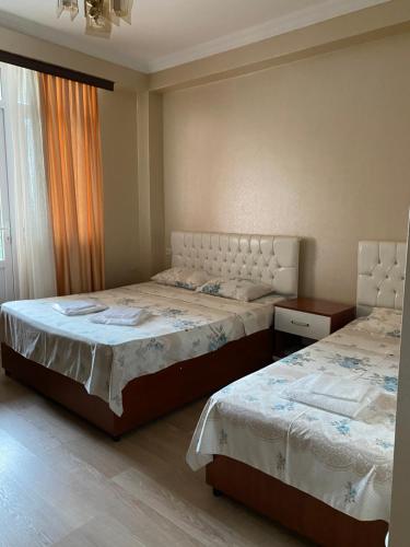 1 dormitorio con 2 camas y ventana en Hotel Eurasia, en Batumi